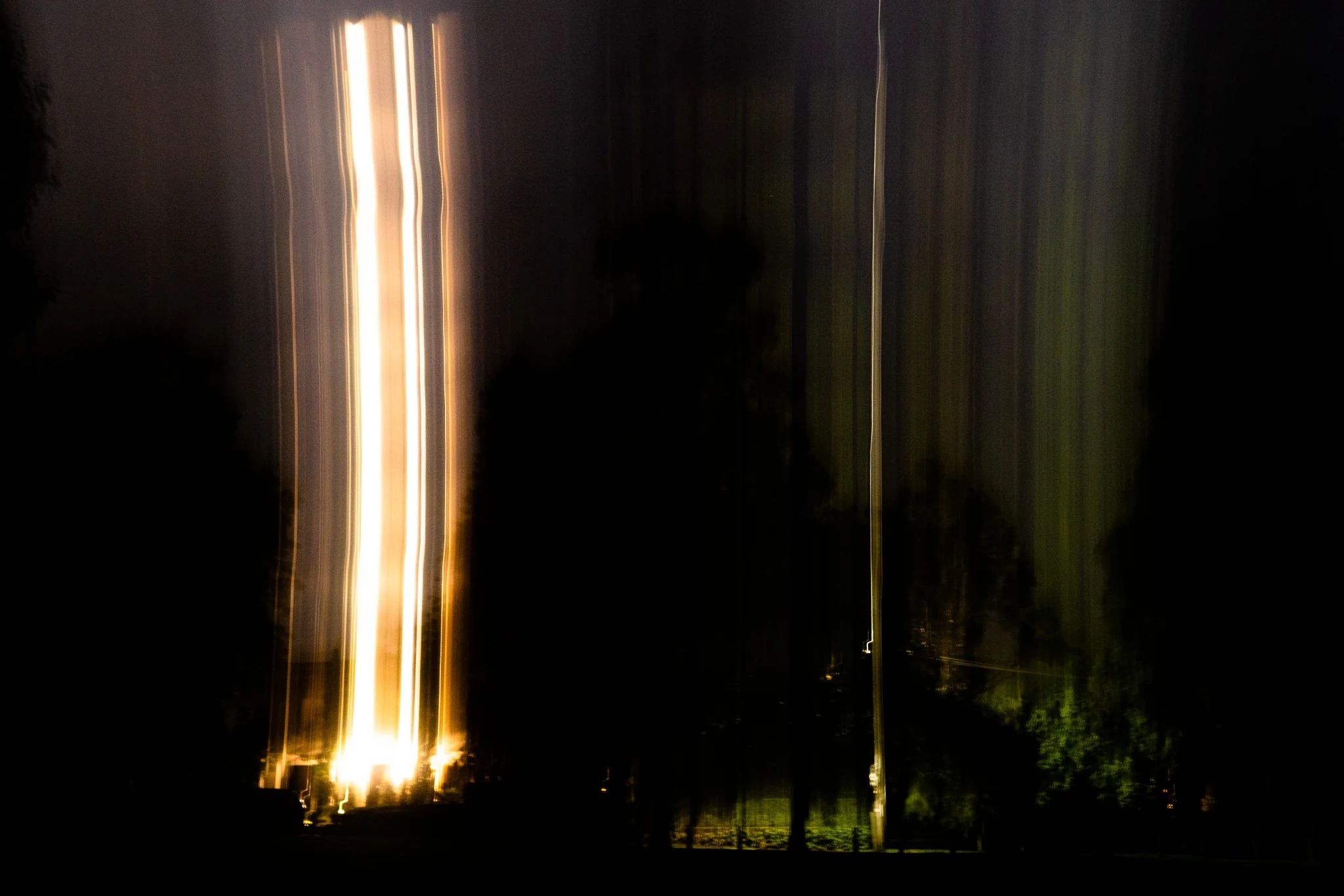 Vertical tower of light in a dark landscape